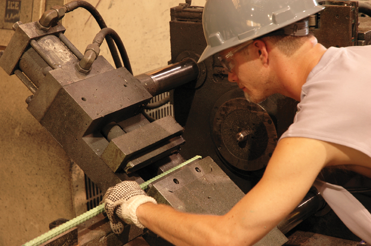 Factory image of man cutting rebar